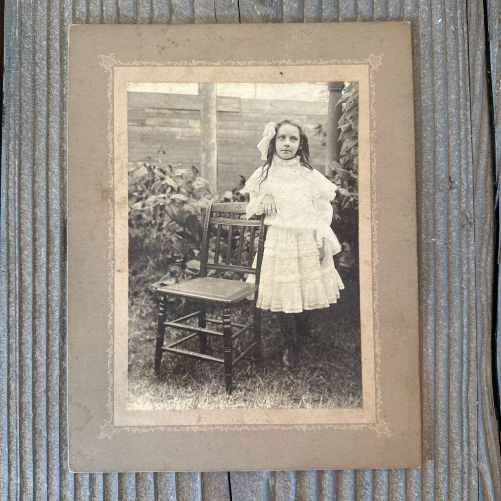 PHOTO CARD OF GIRL POSING BESIDE CHAIR